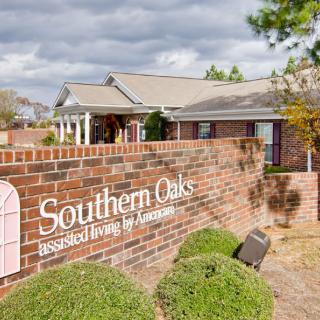 Entrance view of Southern Oaks Assisted Living with a prominent brick sign and surrounding greenery.