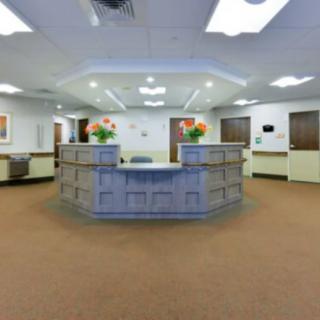 A spacious reception area with a central desk adorned with flowers.