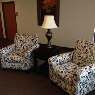 A cozy seating area with patterned chairs and a central lamp.