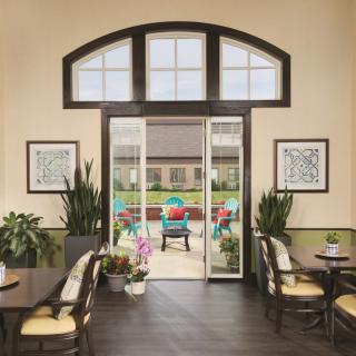 A cozy dining area with a view of a colorful patio through large glass doors.