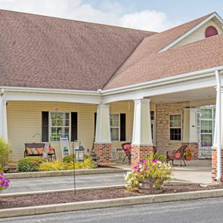 A cozy residential building with a front porch and garden.