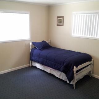 A minimalist bedroom with a single bed and blue bedding.