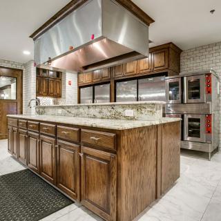 Spacious modern kitchen with a central island and stainless steel appliances.