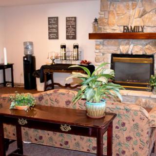 A cozy living room with a fireplace, plants, and inviting decor.