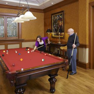 Two individuals enjoying a game of pool in a stylishly designed room.