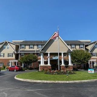 A well-maintained building with a flagpole and surrounding greenery under a clear blue sky.