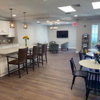 A modern open-plan living and kitchen area with seating and a wall-mounted television.