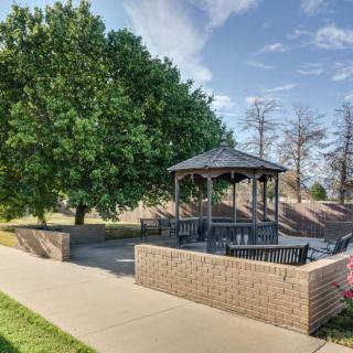 A peaceful park setting with a gazebo surrounded by trees and benches.