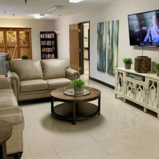 A modern living room with comfortable seating and a large TV on the wall.