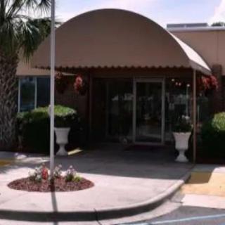A building entrance with an awning and potted plants.
