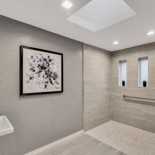 A modern, minimalist bathroom featuring a walk-in shower with recessed lighting and elegant tile design.