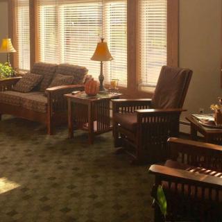 A cozy living room with comfortable seating, warm lighting, and large windows.