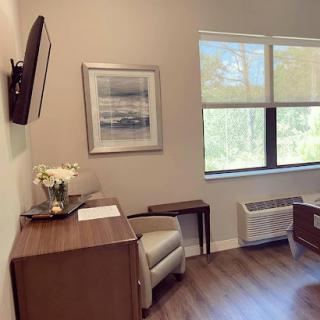 A serene waiting room featuring a comfortable chair, modern furniture, and calming artwork.