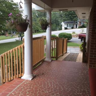 A view from the porch overlooking a garden and surrounding neighborhood.