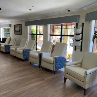 A row of comfortable chairs in a bright waiting area with large windows.