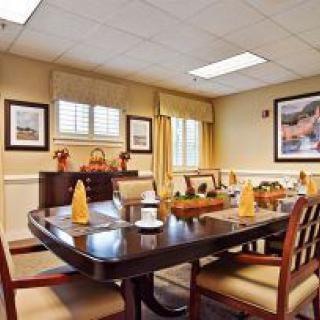 A well-decorated dining or meeting room with a large table, chairs, and elegant decor.