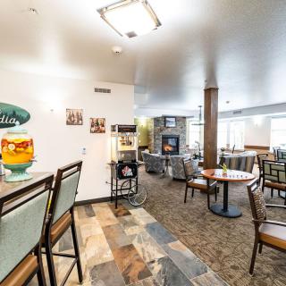 A cozy cafe interior with seating, tables, and a beverage dispenser.