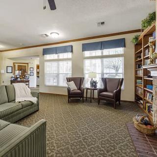 Cozy living room with a sofa, two chairs, and a bookshelf.