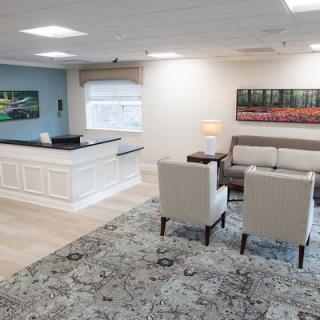 A modern office reception area with a desk and comfortable seating arrangement.