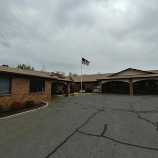 A view of a residential building with an American flag flying under a cloudy sky.