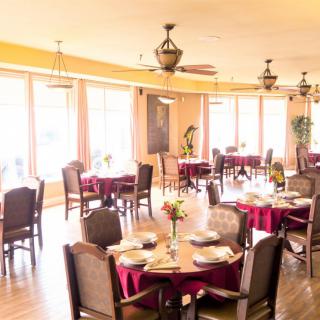 A well-lit restaurant dining area with neatly arranged tables and chairs.