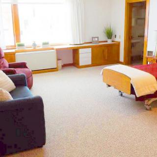 A serene therapy room featuring a comfortable massage table and cozy seating.
