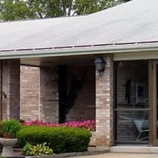 A brick house with well-maintained landscaping and a covered entrance.