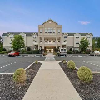 A hotel building with a large entrance and a surrounding parking lot.