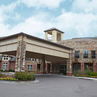 A modern building with a covered entrance and stone facade.
