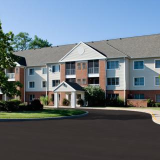 A three-story residential apartment building with a well-maintained exterior.