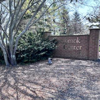 Entrance to the park with a welcoming sign amidst lush greenery.