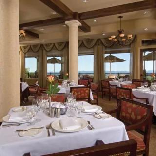 Elegant dining area with a view overlooking the outdoors through large windows.
