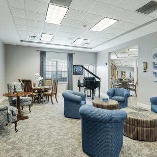 A well-furnished lounge area with comfortable seating and a piano.