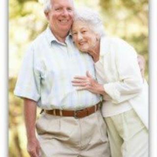 An elderly couple enjoying a moment together outdoors.