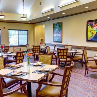 An inviting dining room with neatly arranged tables and chairs, featuring elegant decor.