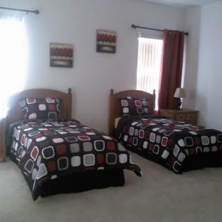 A modern bedroom featuring two twin beds with geometric patterned bedding and coordinated decor.
