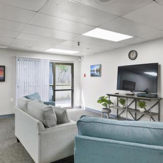 A modern living room featuring comfortable sofas, a television, and stylish decor.