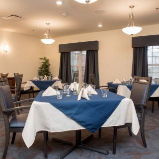 Elegant dining area set with neatly arranged tables adorned with navy and white tablecloths, ready for guests.