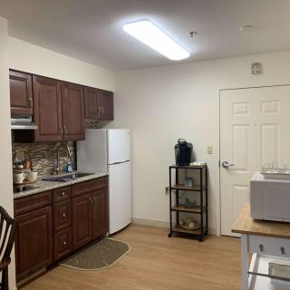 A cozy apartment kitchen with wooden cabinets and a refrigerator.