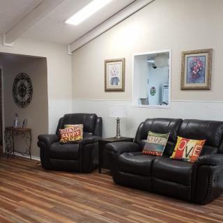 A cozy living room with leather seating and colorful pillows.