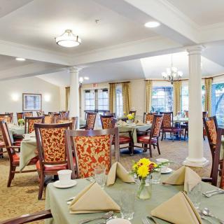 An elegantly decorated dining room with neatly set tables and comfortable chairs.