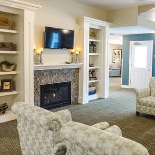 A cozy living room with a fireplace, built-in shelves, and comfortable seating.