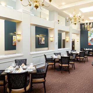 An elegant dining room with chandeliers and neatly arranged tables.