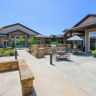A sunny courtyard featuring outdoor seating and a modern architectural design.
