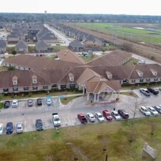 Aerial view of a suburban residential neighborhood with a central building and a parking lot filled with cars.