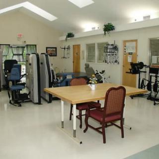 A physical therapy room equipped with exercise machines and furniture.