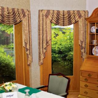 A classic dining room interior with elegant window drapes and wooden furniture.