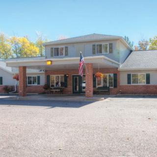 A two-story motel building with a parking lot and an American flag displayed at the entrance.