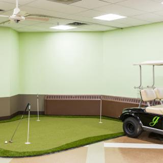 A cozy indoor putting green with a golf cart, perfect for practicing your swing.