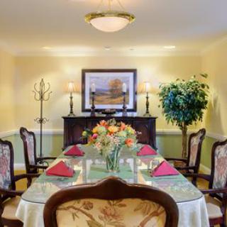 A beautifully set dining table with floral centerpiece in a tastefully decorated dining room.